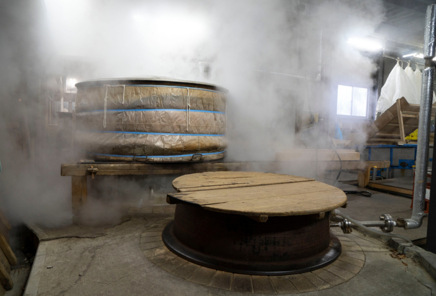 大きな鍋で米を蒸している