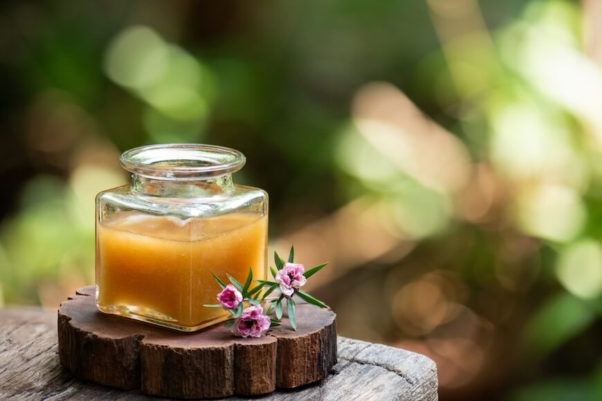 マヌカの花とガラス瓶に入ったマヌカハニー