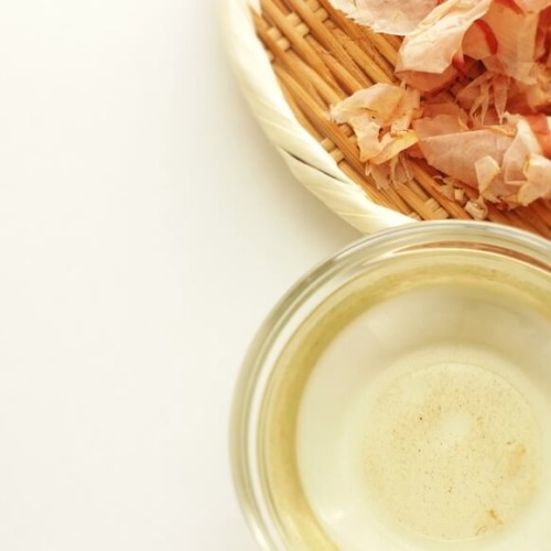 ザルに乗った鰹の削り節とカラス容器に入った鰹だし