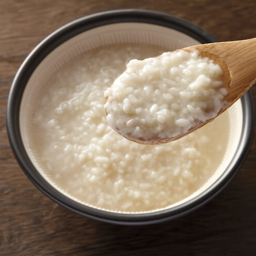 陶器に入った塩麹を木製のスプーンで掬っている様子